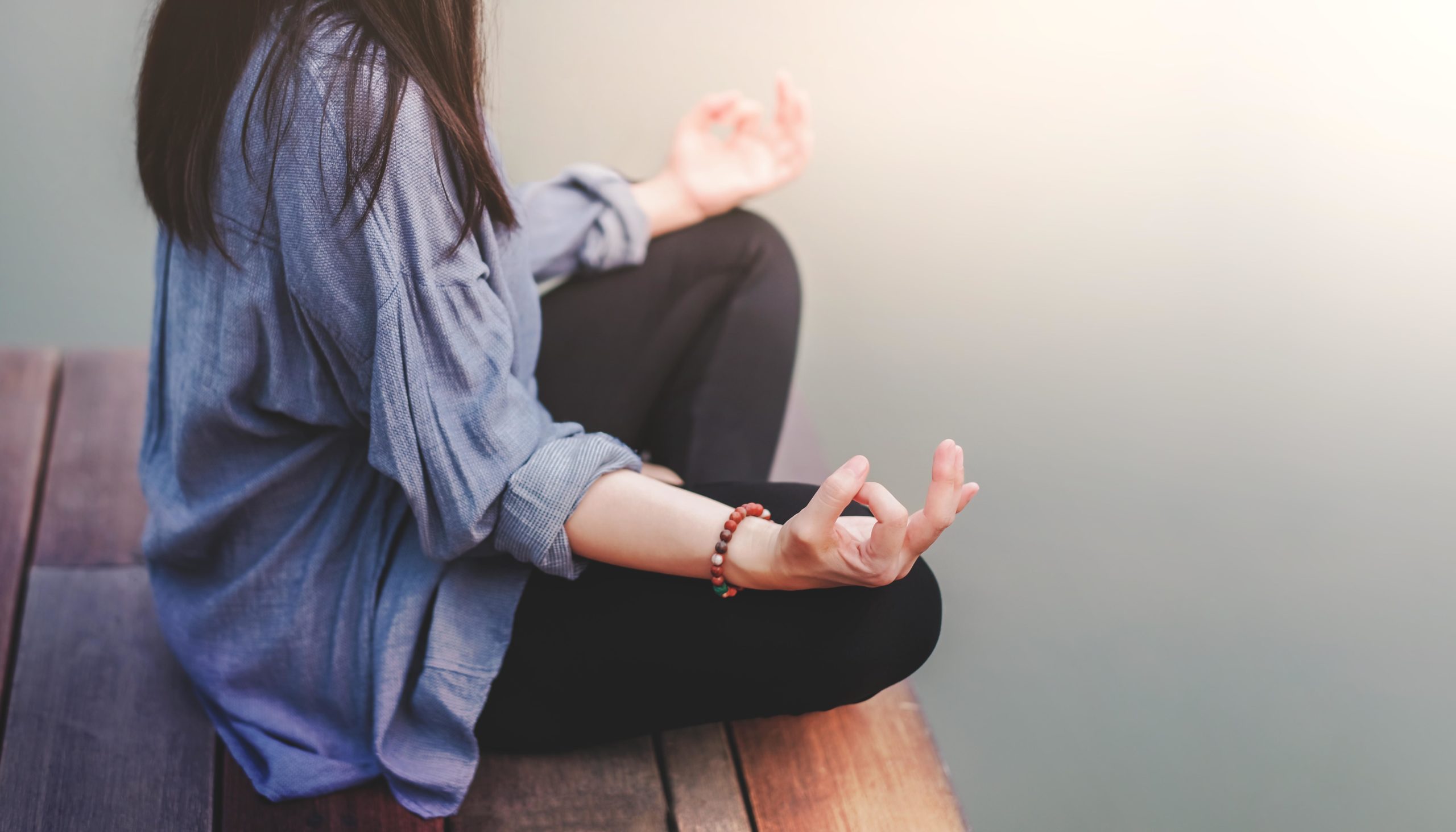 Young woman practices yoga in outdoor. Sitting in lotus position
